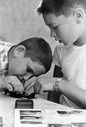 Teenagers help younger boys build model cars