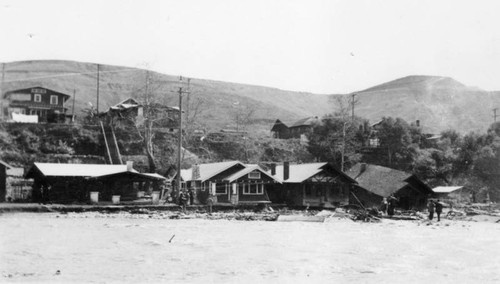 Flood waters roll past houses