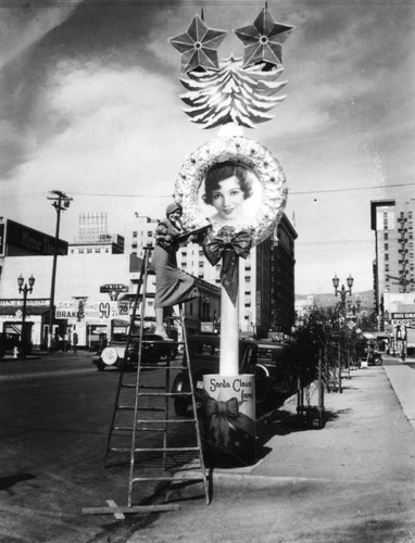 Claudette Colbert on ladder on Hollywood Blvd