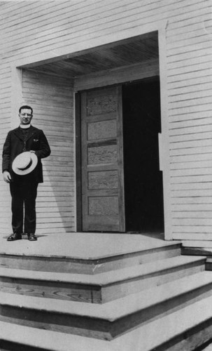 Priest in front of church