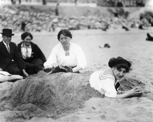 Young woman buried in the sand