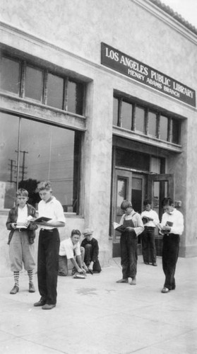 Boys reading in front of the Henry Adams Branch