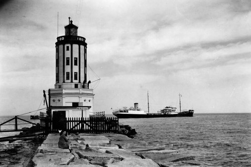 Lighthouse at the end of the breakwaters — Calisphere