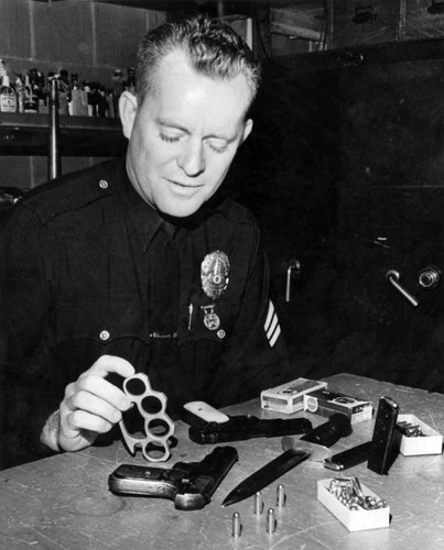 Policeman checks gang weapons