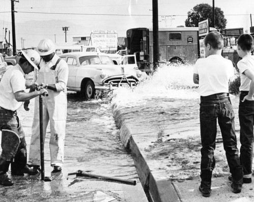 Broken hydrant bothers workmen, fascinates boys