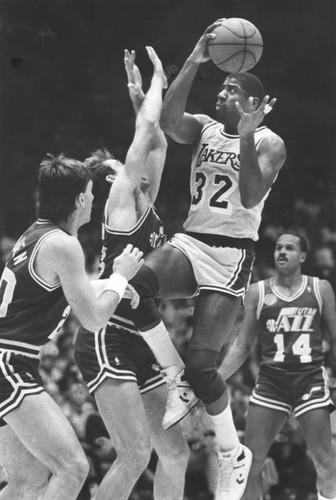 Magic Johnson tosses in two points over Utah's Marc Iavaroni