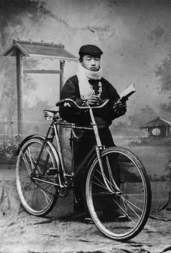 Studio portrait of Japanese boy with bicycle