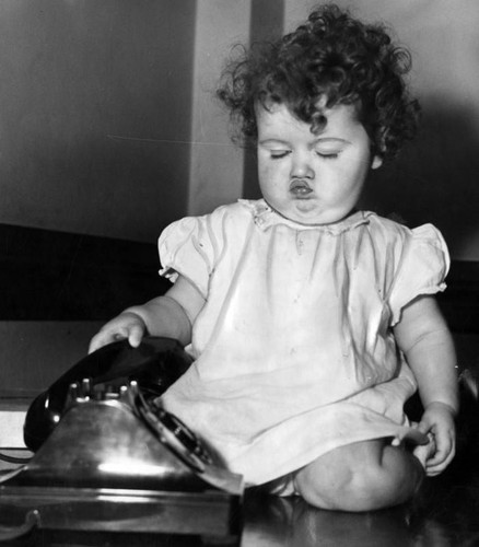 Little girl plays with a telephone