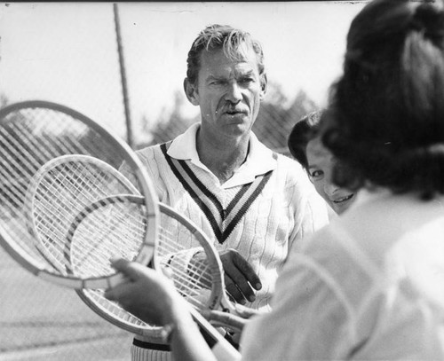 Steve Cornell gives tennis lesson to young ladies