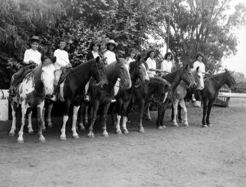 Unidentified young girls ride horseback