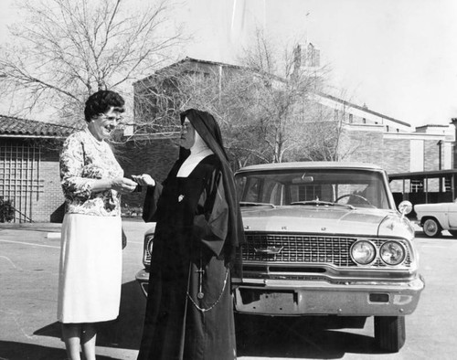 Mrs. Charles Stein gives key to new car to Sister Mary Vincent