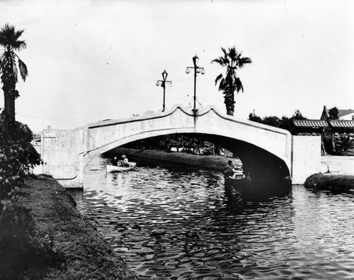 Gondolas pass under bridge, Venice canal