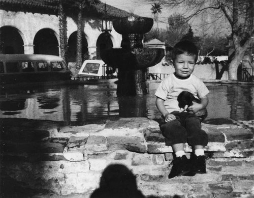 Child with puppy at San Fernando Mission