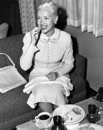 Betty Grable taking time out to eat light meal