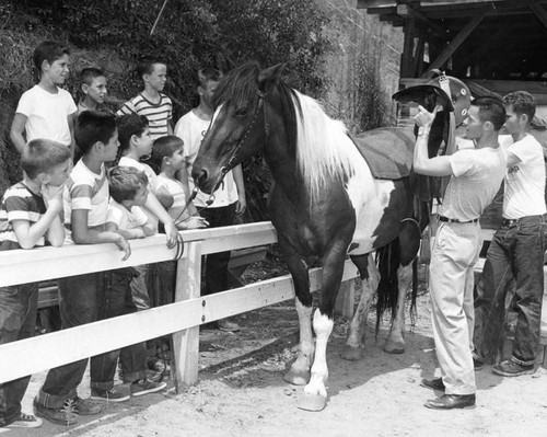 Boys learn to saddle horse