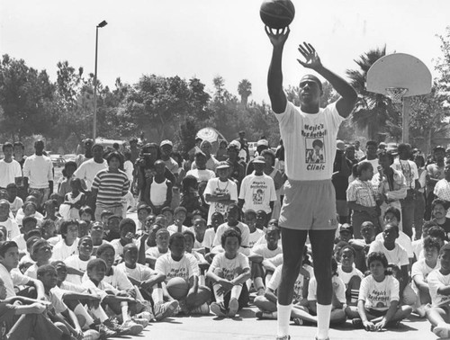 Magic demonstrates technique at a basketball clinic