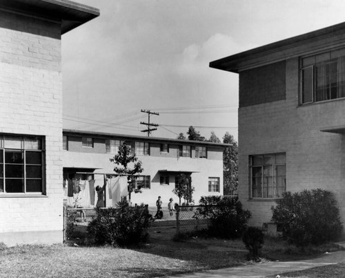 Residents hanging washed clothes, Ramona Gardens