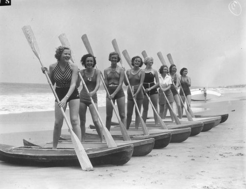 Beach beauties pose with kayaks, view 1