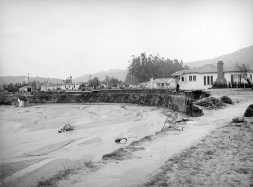 L.A. River flooding, house hanging over the edge in North Hollywood