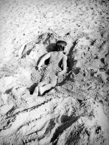 Girl playing in the sand at the beach