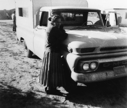 American Indian woman leaning on truck