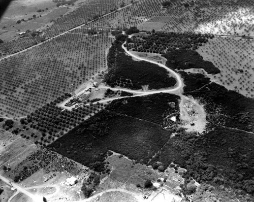 Aerial view of an oil derrick on farm land