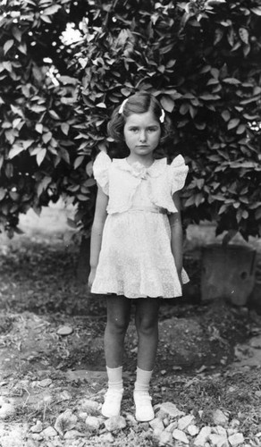 Young girl in front of tree