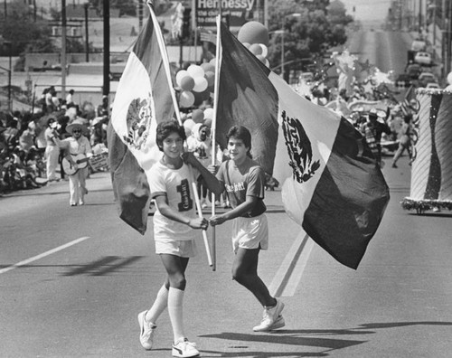 Two boys with Mexican flags in parade