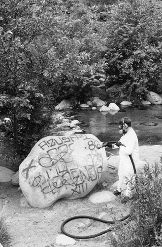 Sandblasting graffiti from a rock