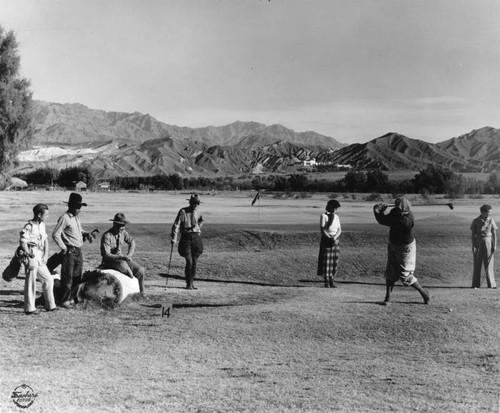 Golfers on the grass golf course at Death Valley's Furnace Creek Ranch