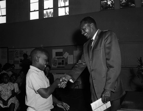 Councilman Tom Bradley presents reading award to students