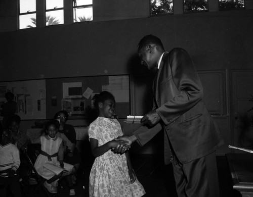 Councilman Tom Bradley presents reading award to students