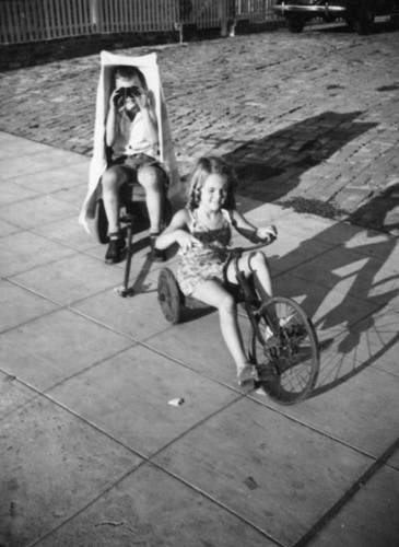 Two children playing on sidewalk