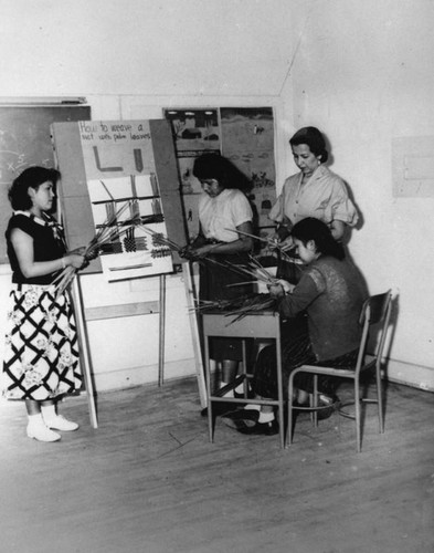 American Indian women weaving mats