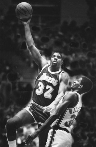 Magic Johnson about to shoot over Reggie Williams