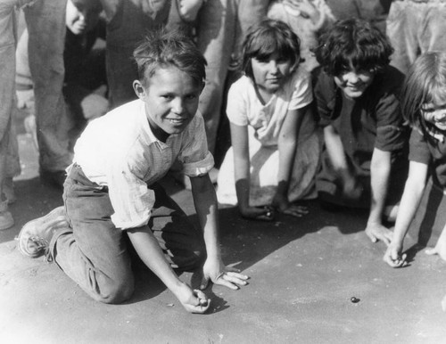 Children playing marbles, view 1