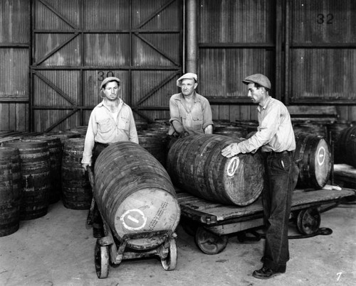 Men moving liquor barrels