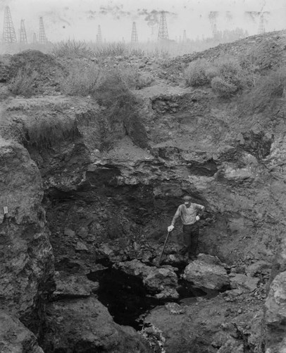 Lone excavator at tar pit, Rancho La Brea