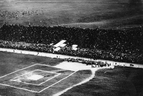 Thousands watch a biplane in flight