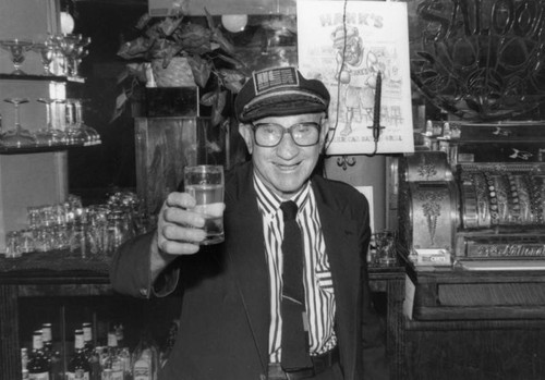Hank of Hank's Bar holding a drink