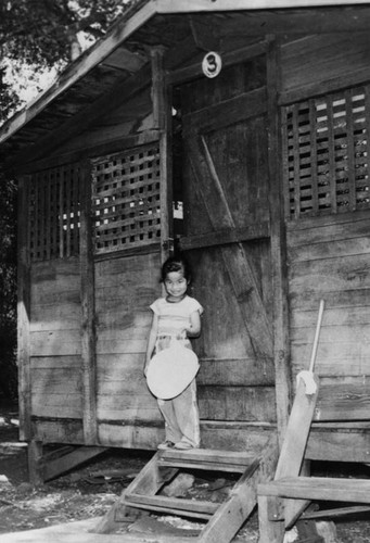 Filipino girl in front of cabin at Camp Throne