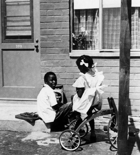 Children on stoop of their new home