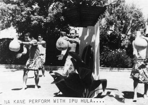 Hawaiian men with gourds perform traditional dance