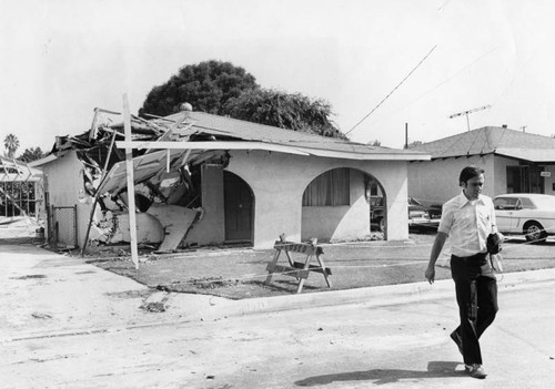 Man in bulldozer rams house