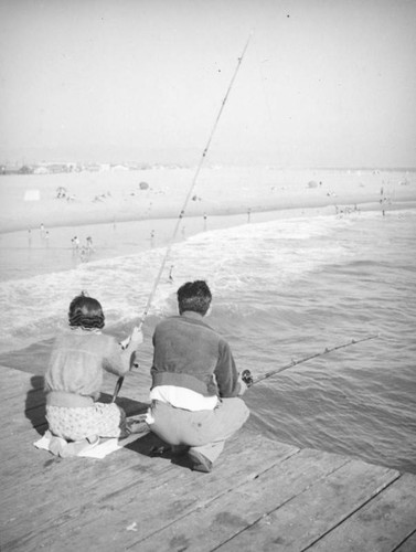 Couple fishing off a Newport Beach pier