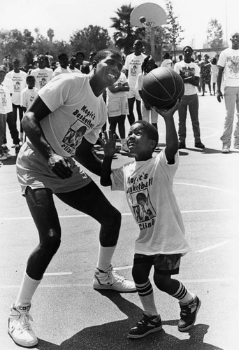 Magic instructs a young ballplayer at East Compton Park /