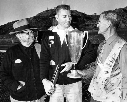 Oldtimers congratulate skeet champ Thinglum, center