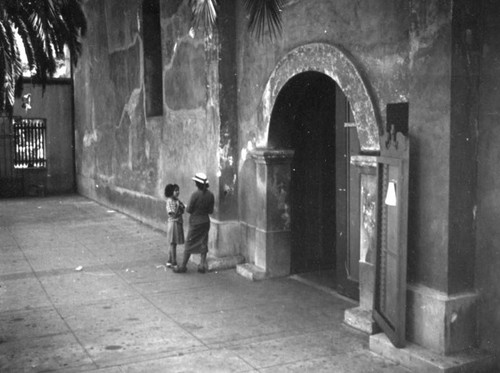 Woman and child by the entrance to the Plaza Church