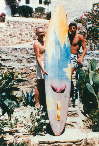 Father and son pose with surfboard