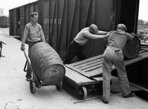 Loading beer barrels onto a railroad car